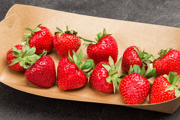 Strawberries in cardboard plate. Ecological tableware