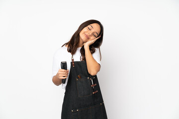 Young hairdresser woman isolated on white background making sleep gesture in dorable expression