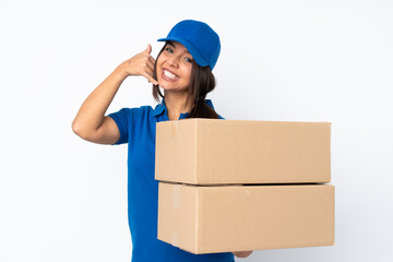 Young delivery brunette girl over isolated white background making phone gesture and pointing front