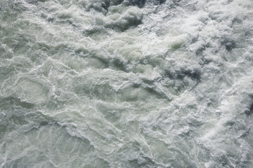 Fototapeta na wymiar Water texture background. Sea waves with white foam.