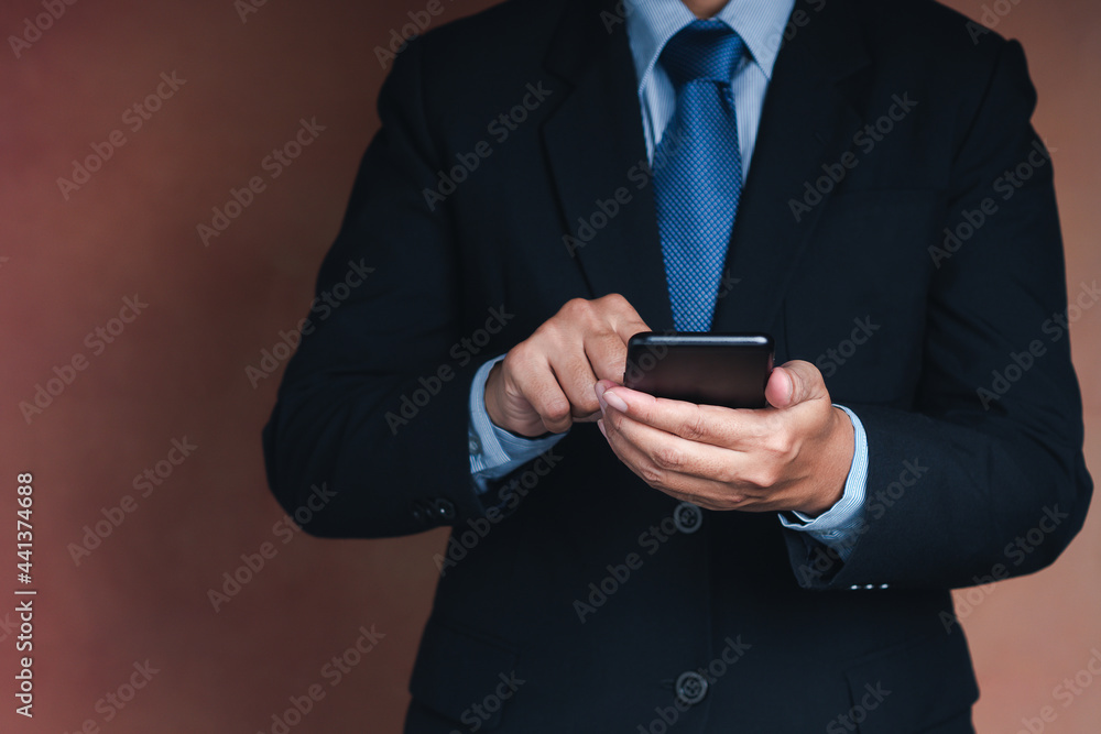 Poster businessman using a smartphone while standing with a brown background. space for text. communication