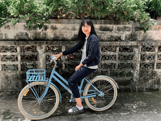 Plakat Asian woman sitting on bicycle at the old town