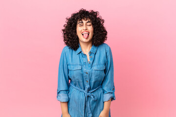 pretty arab woman with cheerful and rebellious attitude, joking and sticking tongue out