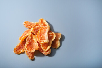 heap of dried tangerines on light blue background