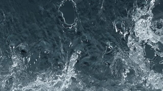 Super slow motion of splashing water isolated on blue background. Filmed on high speed cinema camera, 1000 fps.