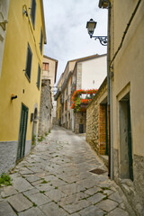 Obraz premium A small street between the old houses of Agnone, a medieval village in the mountains of Molise region in Italy.