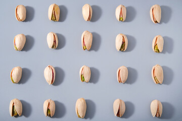evenly arranged rows of fresh pistachio nuts, good snack for vegan or vegetarian, pattern background