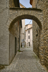 Fototapeta na wymiar A small street between the old houses of Agnone, a medieval village in the mountains of the Molise region, Italy.