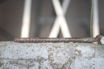 A iron-steel rod, reinforcement material for construction industrial, it placed on the concrete wall at the renovation working site.