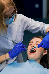 The dentist treats the patient's teeth. Puts braces on a girl. Dentist's office.