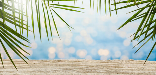 Summer background of sand with green palms and sea landscape 