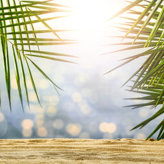 Summer background of sand with green palms and sea landscape 