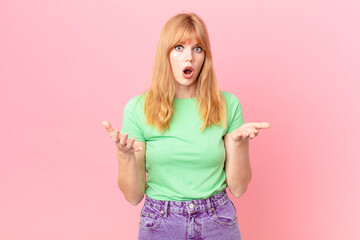 pretty red head woman amazed, shocked and astonished with an unbelievable surprise