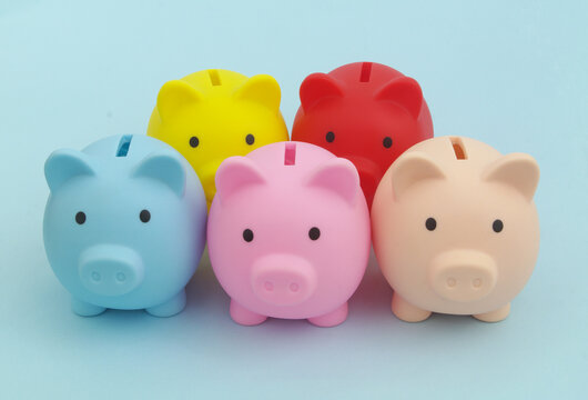 Many Colorful Piggy Banks On Blue Background. 