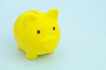 Yellow piggy bank on blue table, space for text.