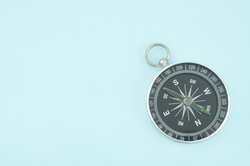 Round black compass on blue background with copy space	
