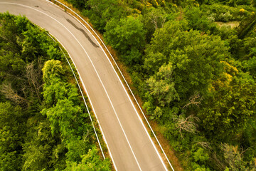 Beautiful idyllic summer landscape of Toscana with mediterranean plants, hills, trees, forests and fields. Sunny evening or morning in Italy. Vacation, recreation mood. Road in hills of Tuscany 