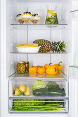 Open fridge full of fresh fruits and vegetables
