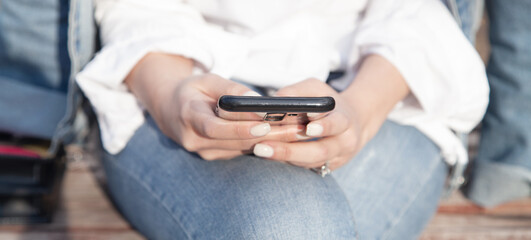 Young woman using mobile phone in outdoors.