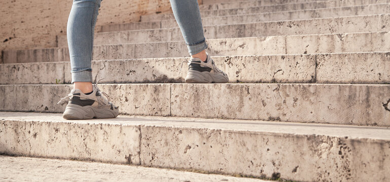 Young Woman Walking Up The Stairs In City.