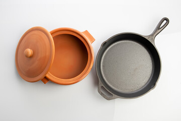 Top View of Cast Iron Skillet and Clay Pots Isolated on White Background