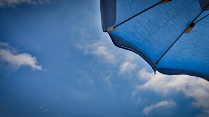 detail of a blue umbrella on the beach by the Ligurian sea, in Spotorno. During the Italian summer