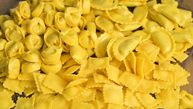 Fresh homemade pasta. Different Tartollini with cheese or meat for cooking in broth, different shapes. Traditional dish for celebrations in italy, Emilia Romagna region. Vertical video,social networks