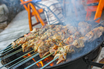 Russian shashlik with skewers barbeque on a grill with smoke.