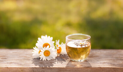 background with chamomile tea on a wooden table top
