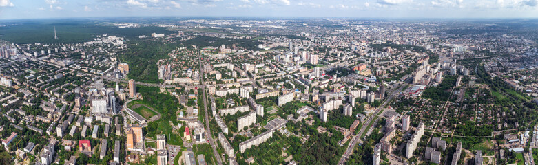 Fototapeta na wymiar Aerial panorama view on green summer Kharkiv city center, Pavlovo pole and park. Botanical garden and multistory modern high residential buildings on bright sunny day