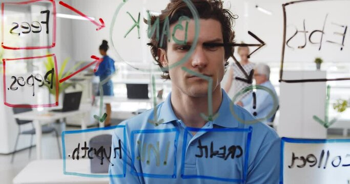 Young pensive man looking at data on glass board in modern office