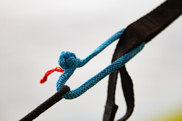 brilliant knot soft shackle woven of blue nylon or polyester rope on nature background. lighter...