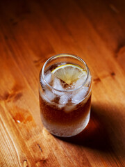Cold espresso coffee tonic in a glass with ice on a wooden table
