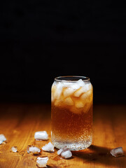 Cold espresso coffee tonic in a glass with ice on a wooden table