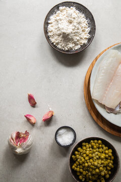 Garlic and salt near fish and peas