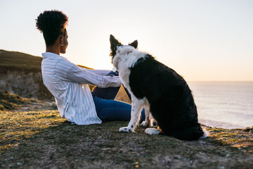 Black woman with dog on beach