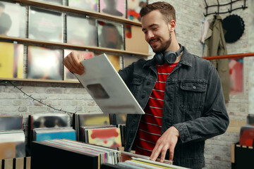 Jeune homme avec disque vinyle en magasin