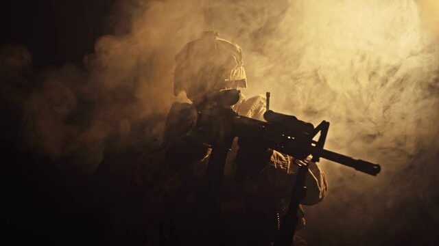 Silhouette of Special Forces Operator in full protection gear with assault rifle, 