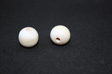 Wooden beads on a black background. Craft.