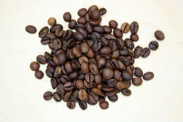 Grains of fragrant fresh coffee on craft paper.