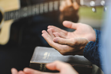 Christian family groups holding hands praying with Holy Bible. and play guitar to sing worship...