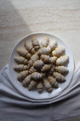 Freshly baked bagels sprinkled with powdered sugar on a white plate.