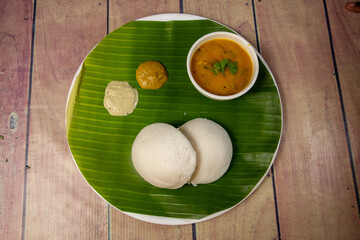 top view of Delicious indian idly with chutney and sambar on banana leaf