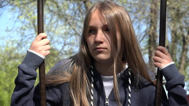 Sad Thoughtful Kid in Swing, Unhappy Child in Park, Depressed Girl Not Playing, Depression of Adolescents in Coronavirus Pandemic 
