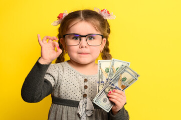 Non-child saving money in children's hands, yellow background and money with baby.