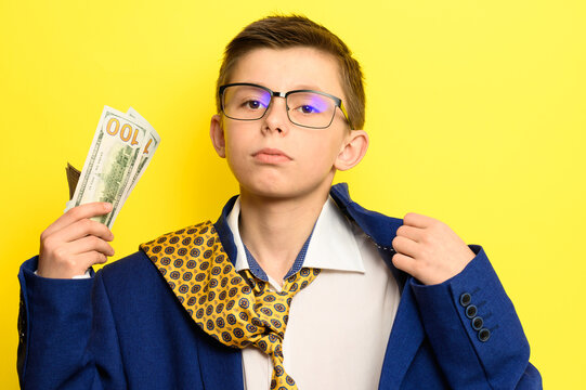 Not A Lot Of Adult Child, Financially Literate Boy, Money In The Hands Of A Child, Portrait On A Yellow Background.