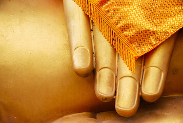 Close up of fingers buddha statue golden color at the temple