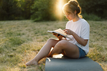 Christian woman holds bible in her hands. Reading the Holy Bible in a field during beautiful...