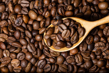 Coffee beans and wooden spoon with coffee close up