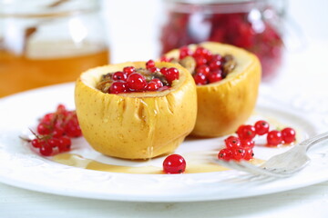 Baked apples with honey, walnuts, currants on a white background